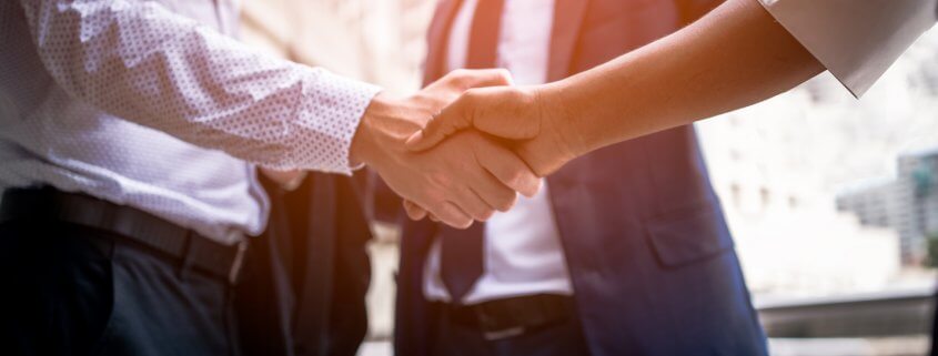 businessman shaking hands with background screening provider