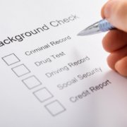 Close-up Of Person Hand Filling Background Check Provider Form