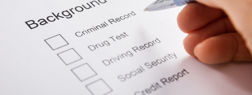 Close-up Of Person Hand Filling Background Check Provider Form